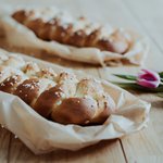 Hefezopf auf einem Holztisch eingebettet in ein Tuch