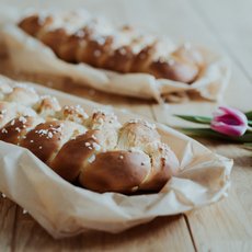 Hefezopf auf einem Holztisch eingebettet in ein Tuch