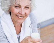 Seniorin mit einem Glas Milch