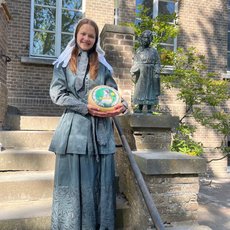 Isabell Schulte-Spechtel als Käsepionierin vor Statue von Maria Reymer