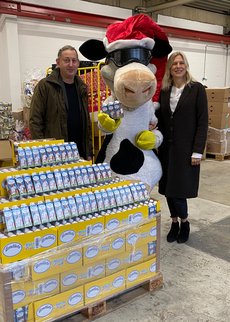 Eva Fischer, Vorstandsmitglied der Tafel Duesseldorf e.V., nimmt die Trinkpaeckchen von Frank Maurer, stellvertretender Geschäftsführer der LV Milch NRW, entgegen. Mit dabei: Kuh Lotte, das Milchmaskottchen der LV Milch NRW