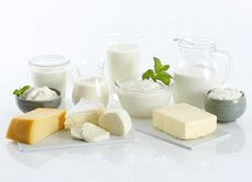 Käse, Butter, Milch und weitere Milchprodukte angeordnet auf einer weißen Fläche