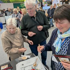 Zwei Besucher testen den Pudding am Stand der LV Milch