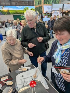 Zwei Besucher testen den Pudding am Stand der LV Milch