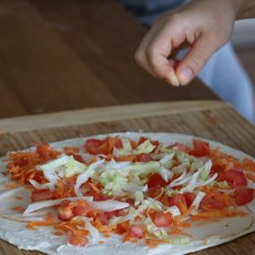 Hand streut Salz auf einen Wrap