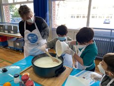 zwei Grundschulkinder kochen in der Schule Milchreis