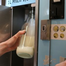 Kunde füllt Milch in einem Milchautomaten ab
