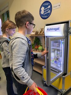 Kinder lernen Einkaufen am Kühlregal