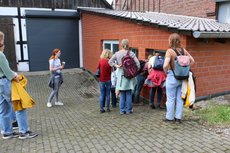 Gruppe guckt durch Fenster in die Hofmolkerei
