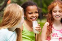 Drei Mädchen trinken mit einem Glas Milch